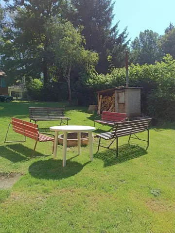 Lavičky a stolek ve stínu stromů