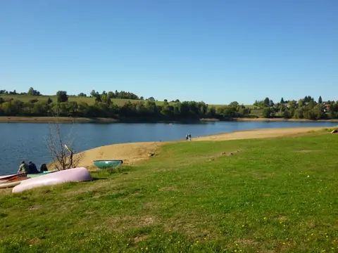 Travnatá pláž s kánoí u vody